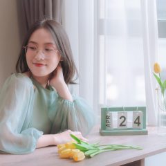 爱思全能版实测编辑苏晚禾在窗边操作测试设备，桌上摆着多台不同系统的手机，绿植与暖色台灯营造出轻松氛围